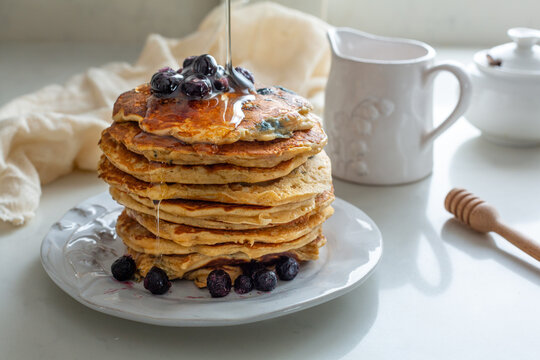 Stack of American Blueberry Pancakes with Syrup Drizzling Down for Shrove Tuesday/Pancake Day Celebration