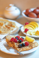 Traditional pancakes with lemon, sugar, raspberries and blueberries for Lent or Shrove Tuesday/Pancake Day celebration