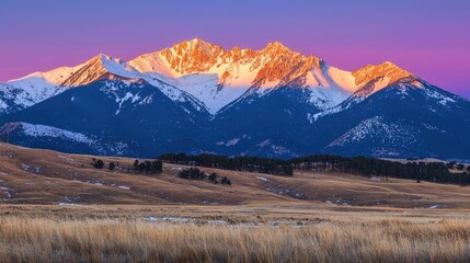 Obraz premium Majestic mountain range at sunset with vibrant colors illuminating the peaks and serene landscape