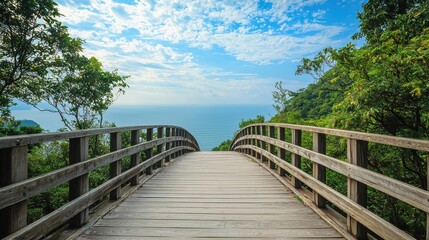 Obraz premium Serene Tropical Scene with Clean Wooden Bridge Leading to Calm Sea Under Blue Skies and Gentle Clouds