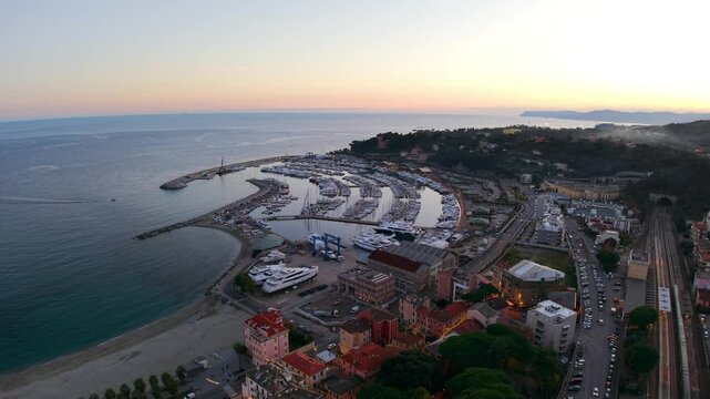 "Drone footage of Varazze at sunset, showcasing a picturesque marina, coastline, and charming townscape."