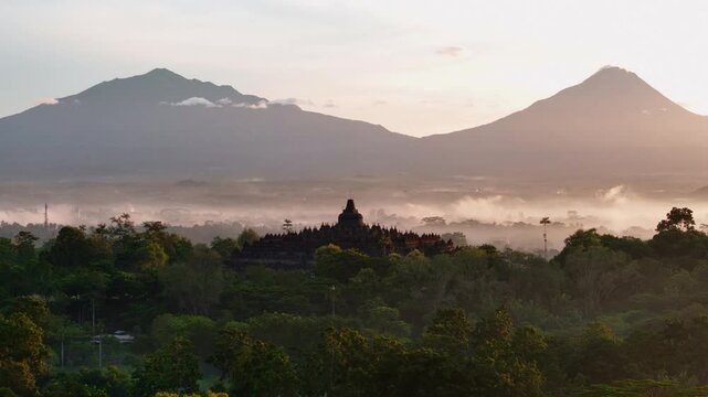 Panoramic view of the Borobudur temple with Merapi and Merbabu volcanos in the background.