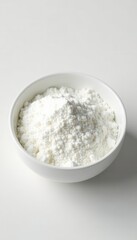 Plain white bowl filled with fine white powder on seamless white backdrop, bright, clean