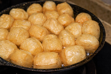 A chef is frying tofu in a pan in the kitchen