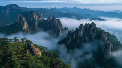 Obraz premium Majestic Mountain Peaks Enveloped in Misty Clouds Scenic Landscape Photography Sky Fog Awe View Blue