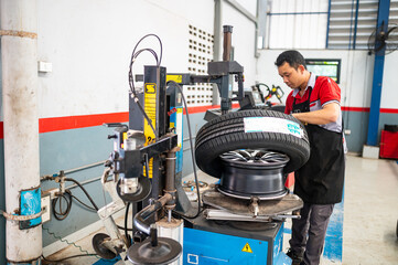 Tire Mounting and Balancing: A skilled technician meticulously mounts and balances a tire onto an...