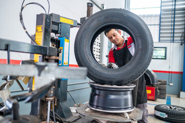 Tire Change: A mechanic meticulously mounts a new tire onto a rim using a specialized machine, showcasing the essential service and skill involved in auto maintenance.