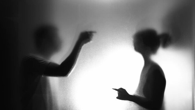 Couple arguing behind the frosted glass