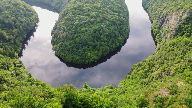 Vltava River meandering through green hills from Viewpoint M&aacute;j at sunset, drone