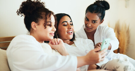 Fototapeta premium Girl, friends and phone in bedroom at spa with sharing, talk and relax with memory on vacation together. Women, group and happy with smartphone, mobile app and social media for bonding at resort