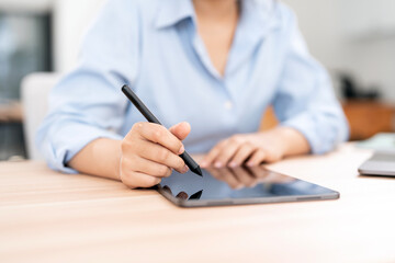 Fototapeta premium Woman hand using stylus pen writing on tablet screen.
