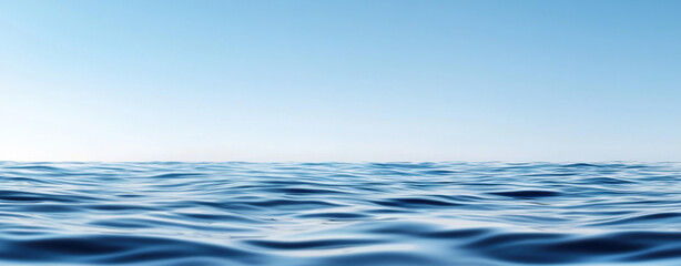 Calm blue ocean water with gentle waves under clear sky