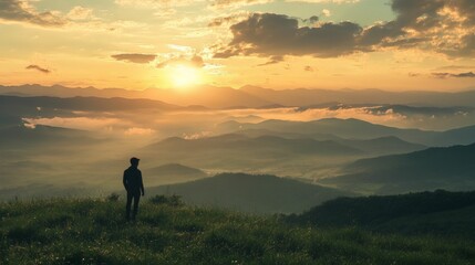 Obraz premium Silhouette of man watching a beautiful sunset in the mountains.