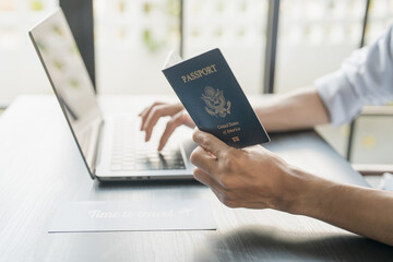 Hand Man Online booking and buying plane tickets using laptop phone and credit card Planning trip...