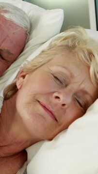 Senior couple sleeping in bed