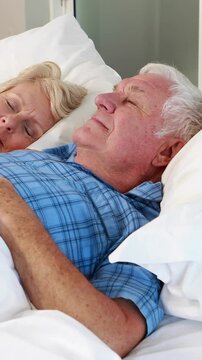 Senior couple sleeping in bed