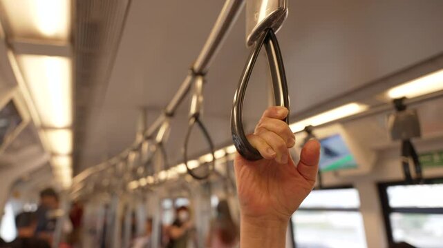 Passenger holds onto handrails and moves around on elevated train