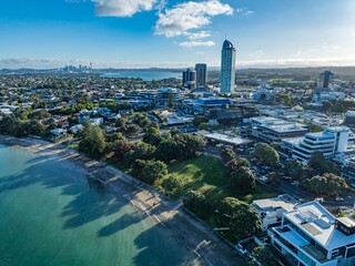 High-angle view of Auckland, New Zealand, showcasing the city's urban sprawl, a beach, and...