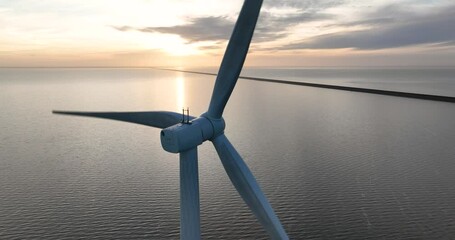 aerial drone footage of a large wind turbine on open water along the Afsluitdijk, The Netherlands. Sustainable energy, electricity by wind power.