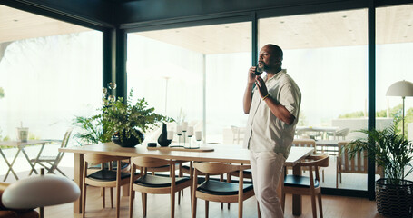 Phone call, house and black man in lounge, conversation and planning with network. African person, apartment and guy with cellphone, mobile app for chatting and discussion with communication