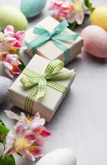 Easter eggs and gift boxes with gingham ribbon and spring flowers decorating a table