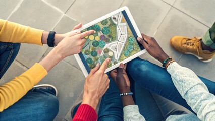 a diverse group of people collaborating on a project, using a tablet to visualize a plan. Their hands are pointing at the screen, indicating active participation and teamwork