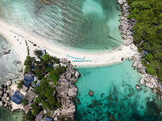 Sandy beach surrounded by turquoise waters, viewed from above with a scenic tropical backdrop. Nang...