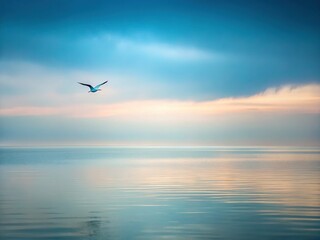 Naklejka premium Minimalist Seascape: Lone Bird Soaring Over Tranquil Ocean, Misty Sky