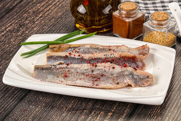 Salted marinated herring fillet with spices