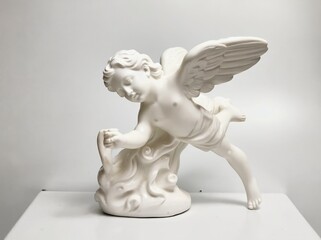 A delicate white porcelain cupid figurine with intricate details, featuring angelic wings and a flowing base design, posed elegantly against a clean white background