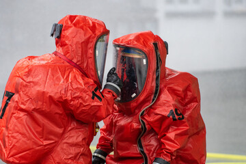 Firefighters in protective hazmat suits at the site of a hazardous toxic gas leak
