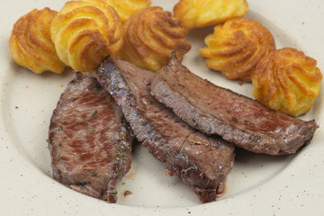 rôti de boeuf cuit et pommes de terre noisette, en gros plan	