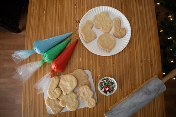 Christmas cookie decorating setup with icing and festive sprinkles