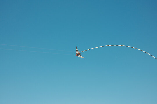 Colorful kite flying high in the clear blue sky