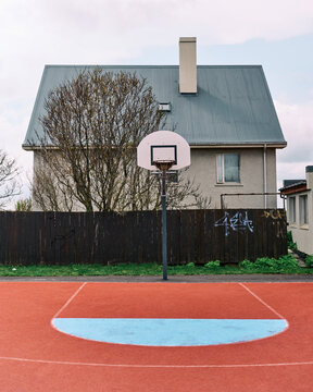 Basketball hoop standing on outdoor court in residential area