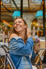 Smiling woman enjoying a coffee moment in Paris bistro.