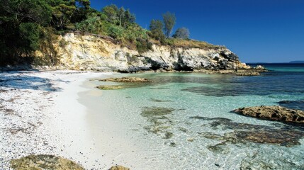 Serene, white sand beach, crystal-clear water, rocky coastline, lush hills, sunny day