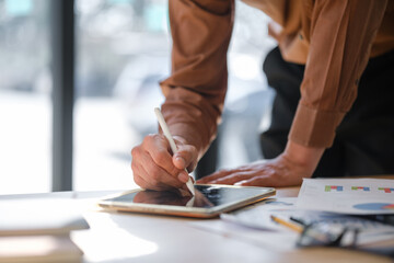Businessman analyzing and signing documents using a digital tablet