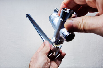 Installing bath mixer tap with long spout using threaded connection.