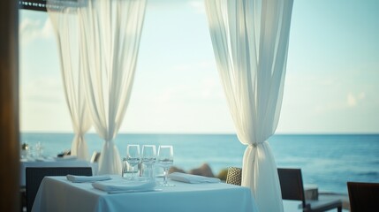 Obraz premium Cozy seaside dining setup with elegant table and beautiful ocean view at sunset
