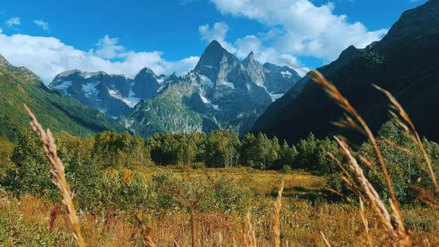 Teberdinsky Nature Reserve. View of Kosygin's glade in the Gonachkhir gorge and the top of Dombai-Ulgen mountain near Lake Tumanly-Kel on a sunny summer day. Panoramic landscape. Resort. 4K