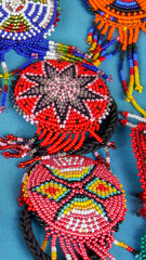 Fototapeta premium Vertical image of Close up of colorful beaded traditional hairpieces sold at the Otavalo market, Ecuador