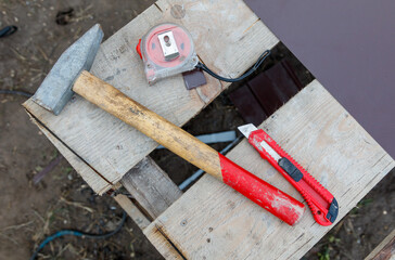 A hammer and a pair of scissors are on a wooden table