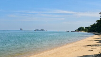 Tranquil Tropical Beach with Clear Blue Waters and Distant Islands