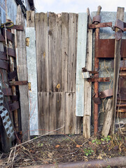 A wooden door with a rusty gate is in front of a building