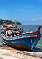Obraz premium Weathered Wooden Fishing Boat Resting on a Sandy Shoreline