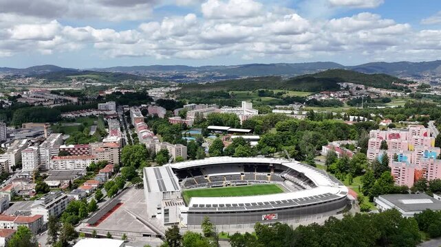 Aerial - Wide view of Est&aacute;dio D. Afonso Henriques in Guimar&atilde;es, Portugal, surrounded by cityscape and green hills