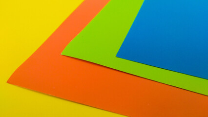 Vibrant colored paper sheets in blue, yellow, orange, green. Perfect for design backgrounds, craft projects, and creative visual compositions