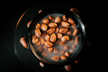 Deliciously roasted hazelnuts in a black bowl on a dark surface for a gourmet snack experience