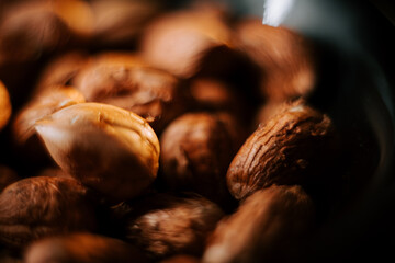Delicious hazelnuts arranged on a plate against a contrasting black background
